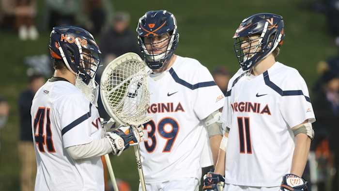 Matthew Nunes, Cole Kastner, and Cade Saustad huddle during the Virginia men's lacrosse game against Richmond at Klockner Stadium.